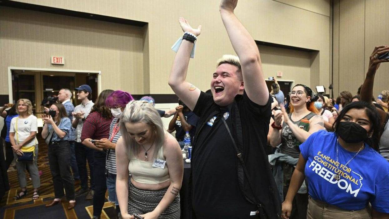 Allie Utley, left, and Jae Moyer, center, of Overland Park, Kan., reacts during a primary watch party Aug. 2, 2022, at the Overland Park Convention Center.