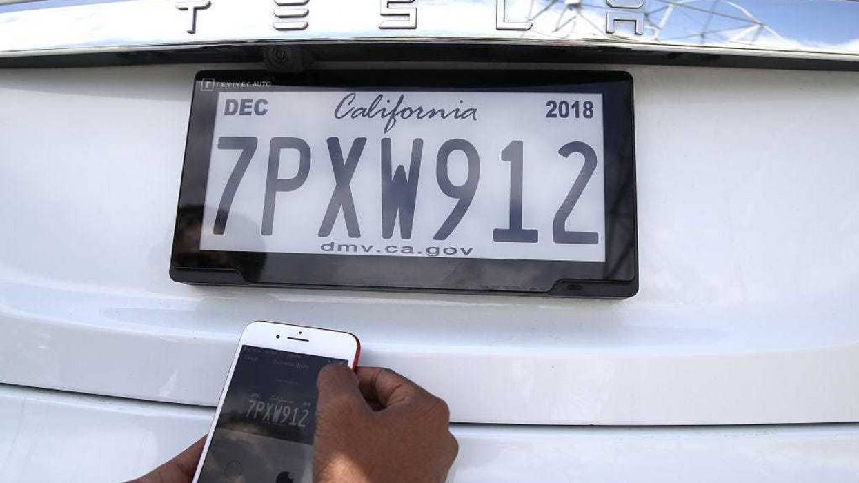 Alok Damireddy uses a smart phone app to make adjustments to a digital license plate made by Bay Area company Reviver Auto, part of a pilot project with the state Department of Motor Vehicles, at Reviver Auto headquarters on May 30, 2018 in Foster City, California.