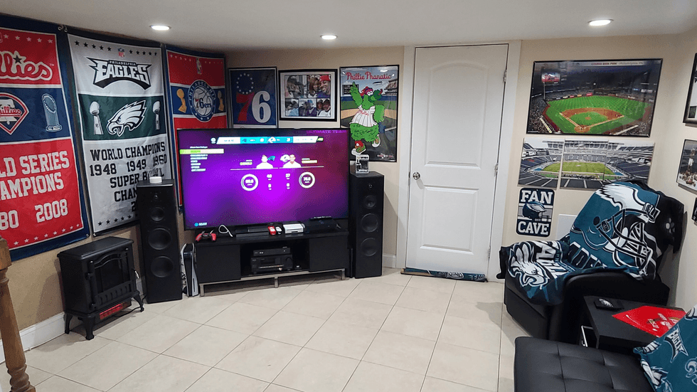 Alvah Brown and Kim West have decked out their West Oak Lane basement -- or "Fam Cave" -- with photos, paraphernalia, gear and other items celebrating Philadelphia sports.