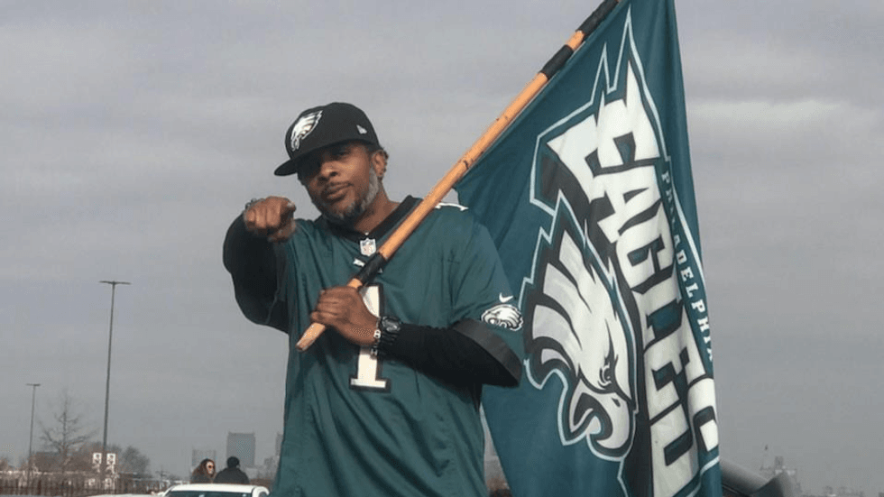 Alvah Brown carrying an Eagles flag and wearing a Jalen Hurts jersey