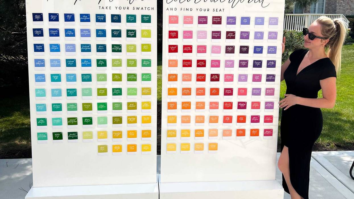 Amanda Tiberi, founder of XO Art and Design, stands next to a seating chart she designed and wrote out for a wedding.