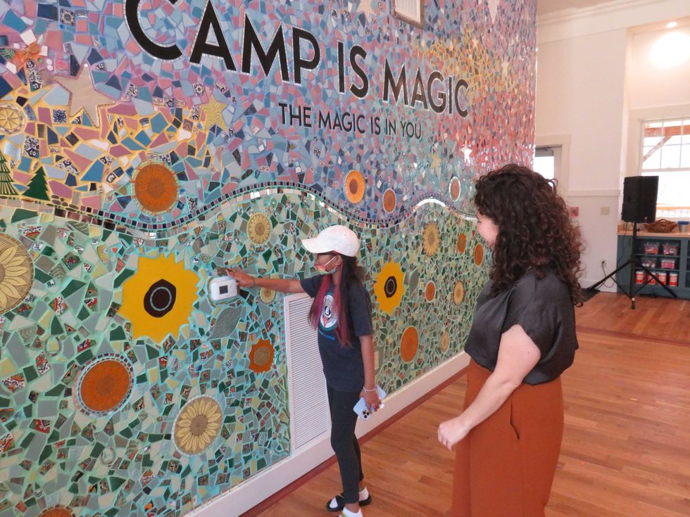 Amarey Brookshire, 13, of West Hartford inspects a 4,500-piece mosaic mural in The Hole in the Wall Gang Camp