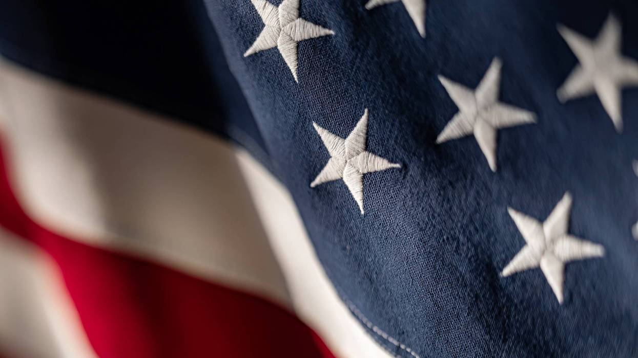 American flag close-up showcasing stars and stripes in rich colors. Texture with selective focus