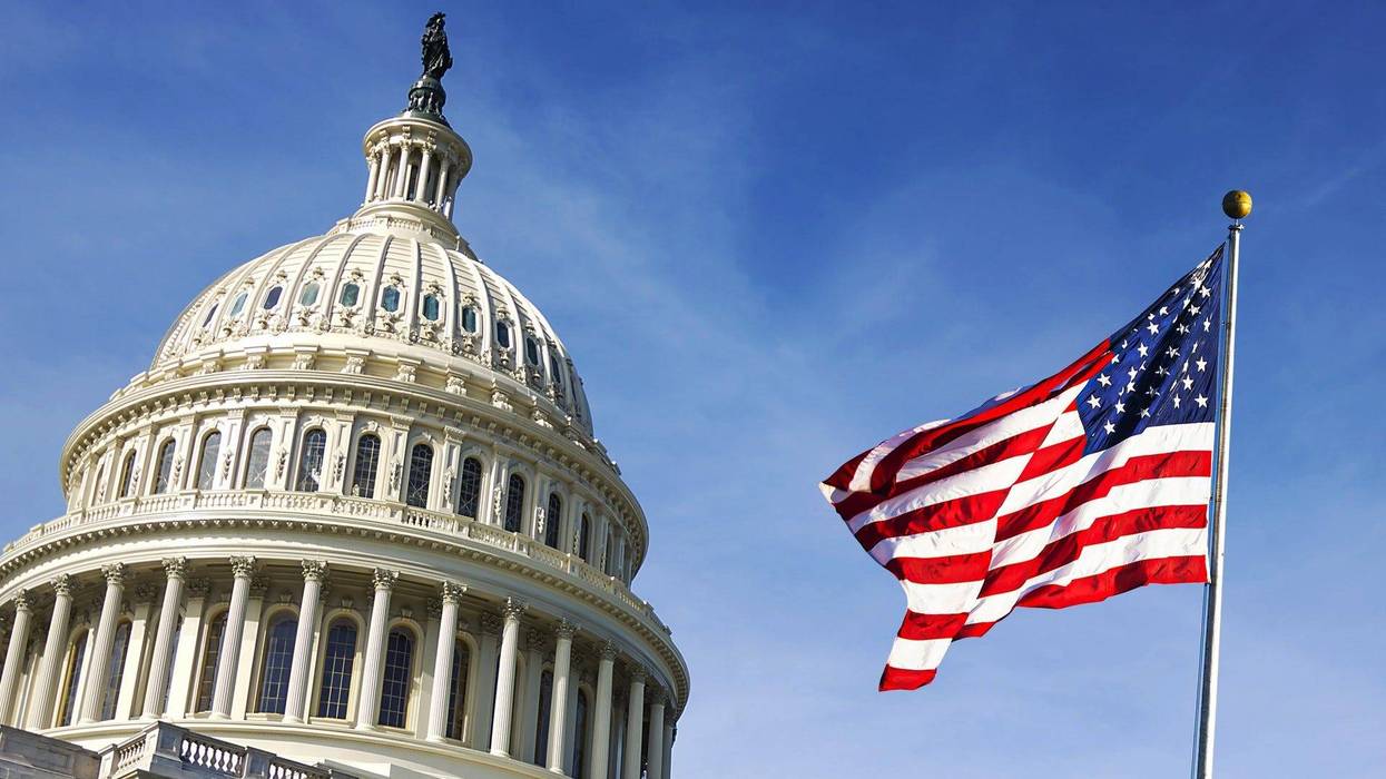American flag waving with the Capitol Hill in the background