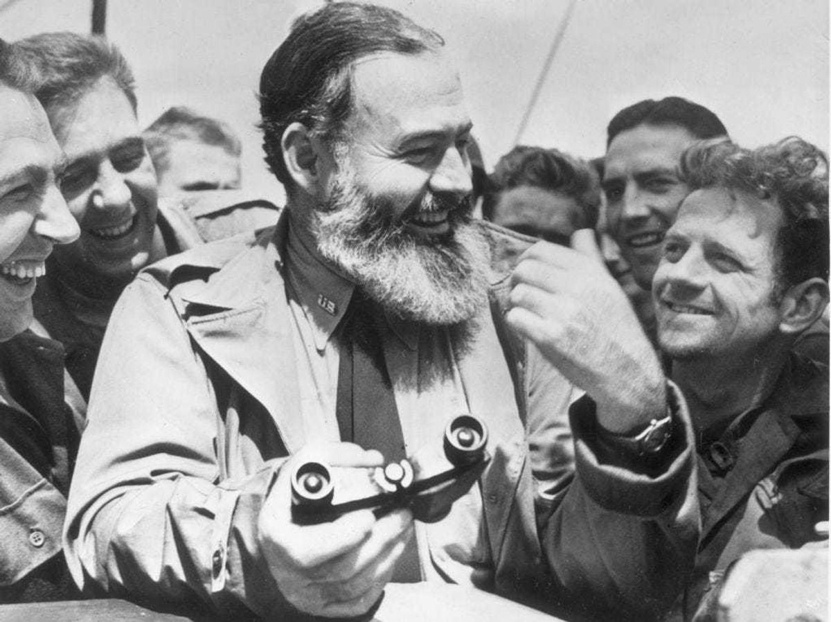 American writer Ernest Hemingway (1899 - 1961) travelling with US soldiers, in his capacity as war correspondent, on their way to Normandy for the D-Day landings. (Photo by Central Press/Getty Images)