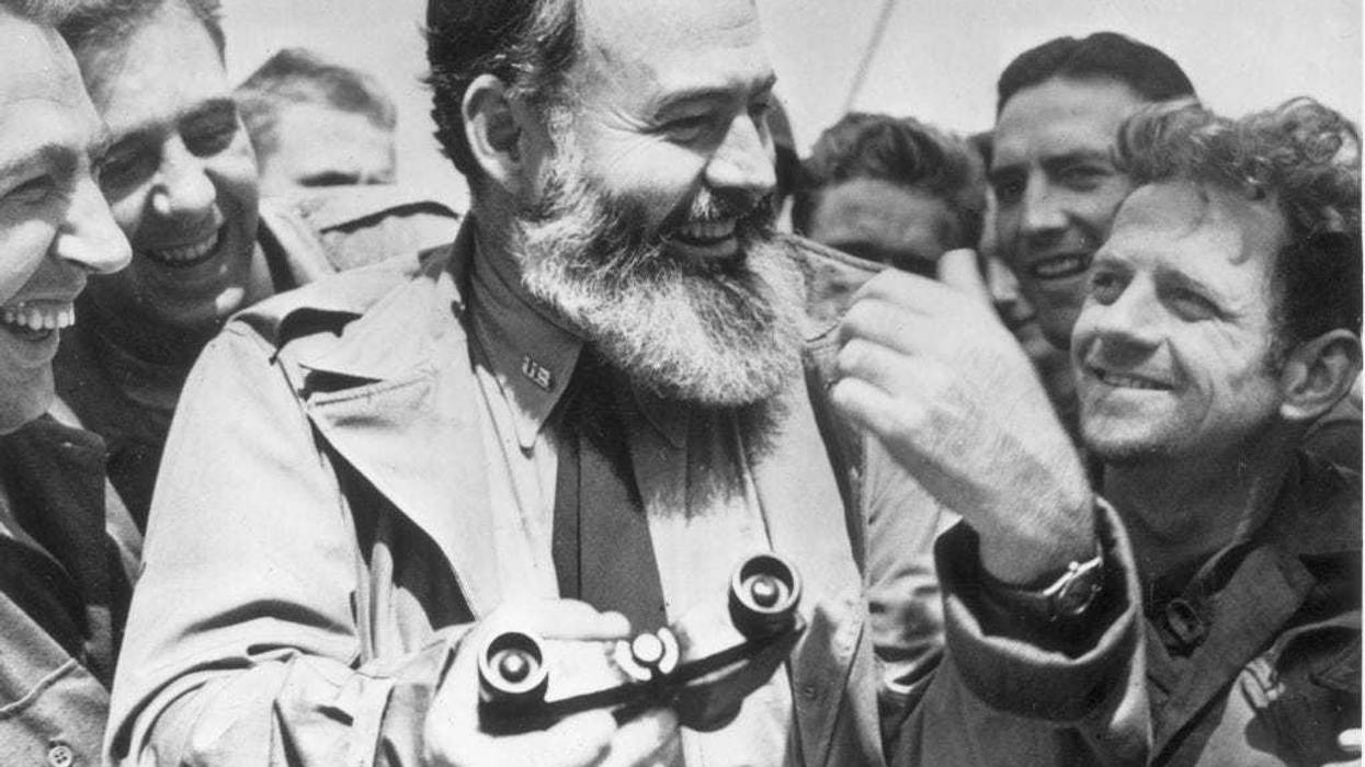 American writer Ernest Hemingway (1899 - 1961) travelling with US soldiers, in his capacity as war correspondent, on their way to Normandy for the D-Day landings. (Photo by Central Press/Getty Images)