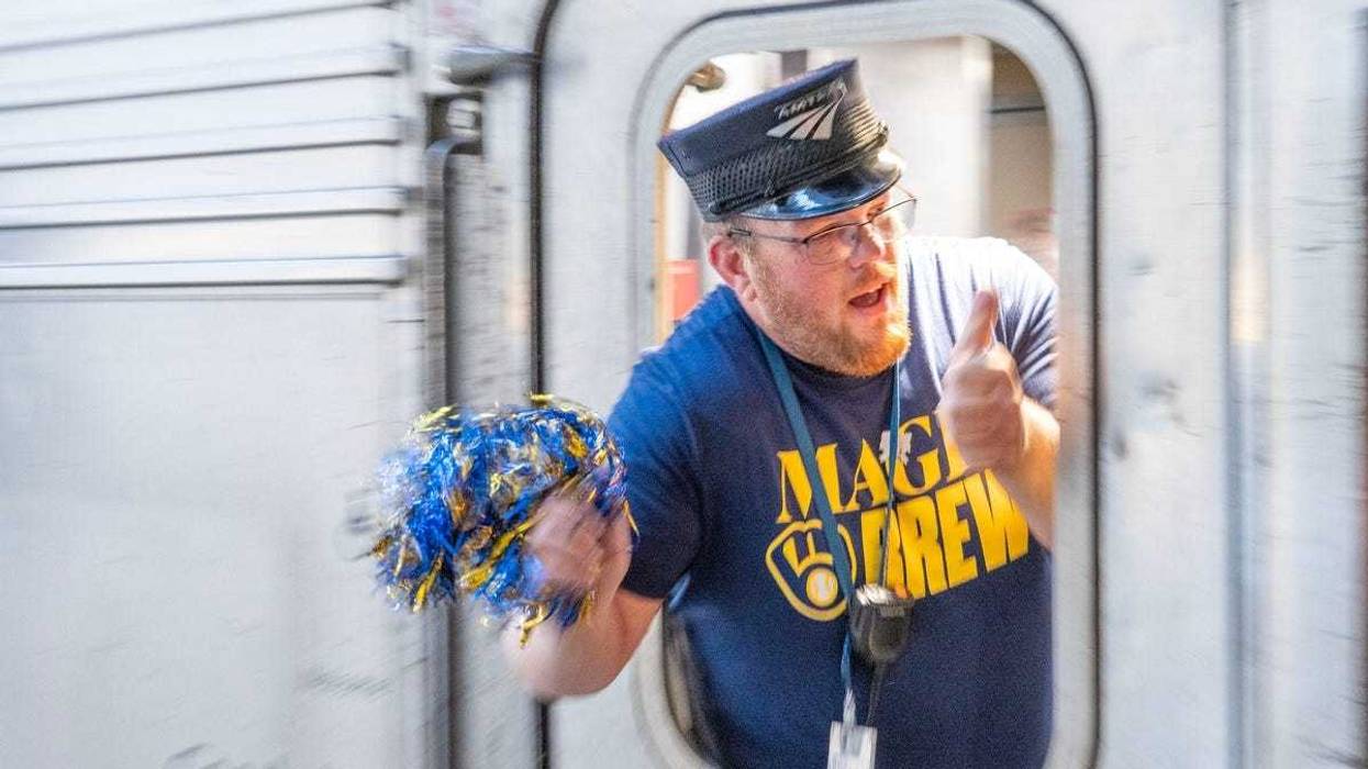Amtrak train conductor, Ben Miller waves a Brewers colored pompom as the Amtrak Hiawatha train leaves the Milwaukee Intermodal Station in Milwaukee, Wisconsin on Oct. 8, 2025, headed for Chicago to watch the Milwaukee Brewers take on the Chicago Cubs in Game 3 of National League Division Series playoff baseball game.