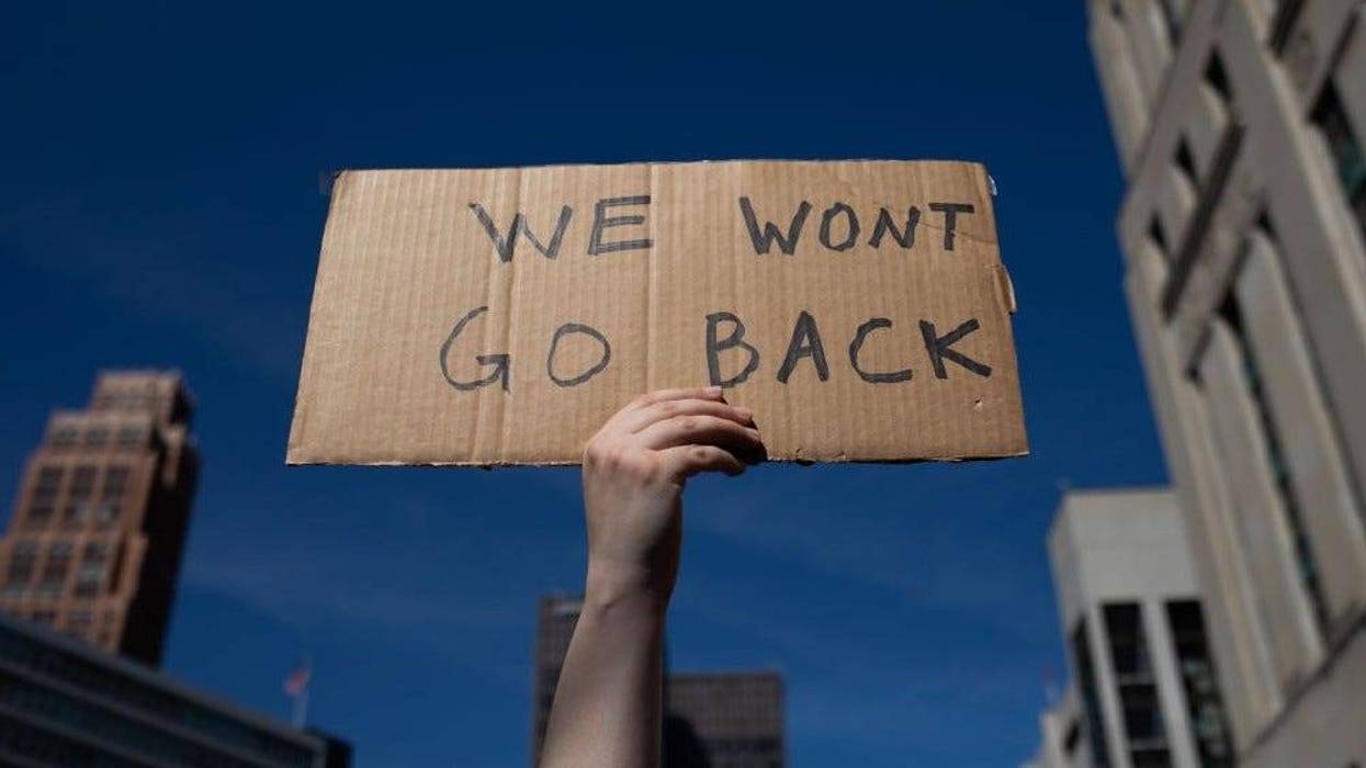 An abortion rights demonstrator raises a sign in the air during a protest of the Supreme Court's Roe v. Wade decision on June 24, 2022 in Detroit, Michigan.