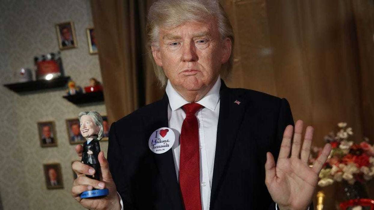 An actor wearing a silicon mask in the likeness of U.S. President Donald Trump poses poses with a Hillary Clinton doll during a presentation at Madame Tussauds on August 14, 2018 in Berlin, Germany.