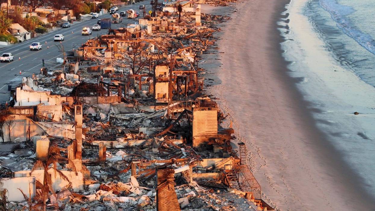 An aerial view of repair vehicles at sunset passing near beachfront homes that burned in the Palisades Fire as wildfires cause damage and loss through the LA region on January 15, 2025 in Malibu, California. Multiple wildfires fueled by intense Santa Ana Winds are still burning across Los Angeles County, with at least 25 dead, more than 12,000 structures destroyed or damaged, and 40,000 acres burned. More than 88,000 people remain under evacuation orders as high winds are forecast.