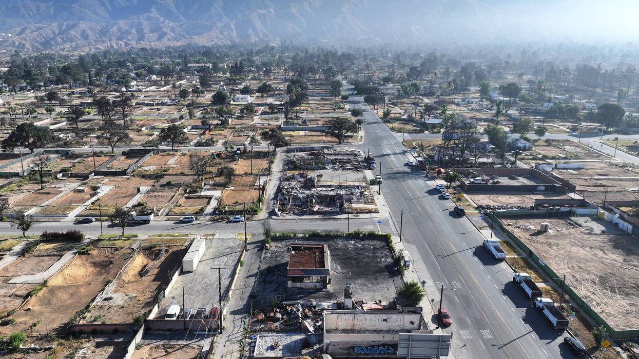 An aerial view of workers clearing a business (BELOW C) which burned in the Eaton Fire on July 07, 2025 in Altadena, California. Today is the six month anniversary of the Eaton and Palisades fires which claimed 30 lives and left more than 16,000 structures destroyed.