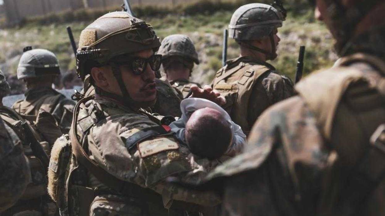 An Airmen comforts an infant