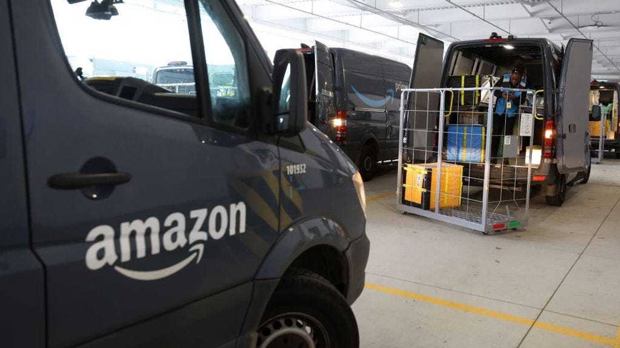 An Amazon driver loads packages into a delivery van at an Amazon delivery station on November 28, 2022 in Alpharetta, Georgia.