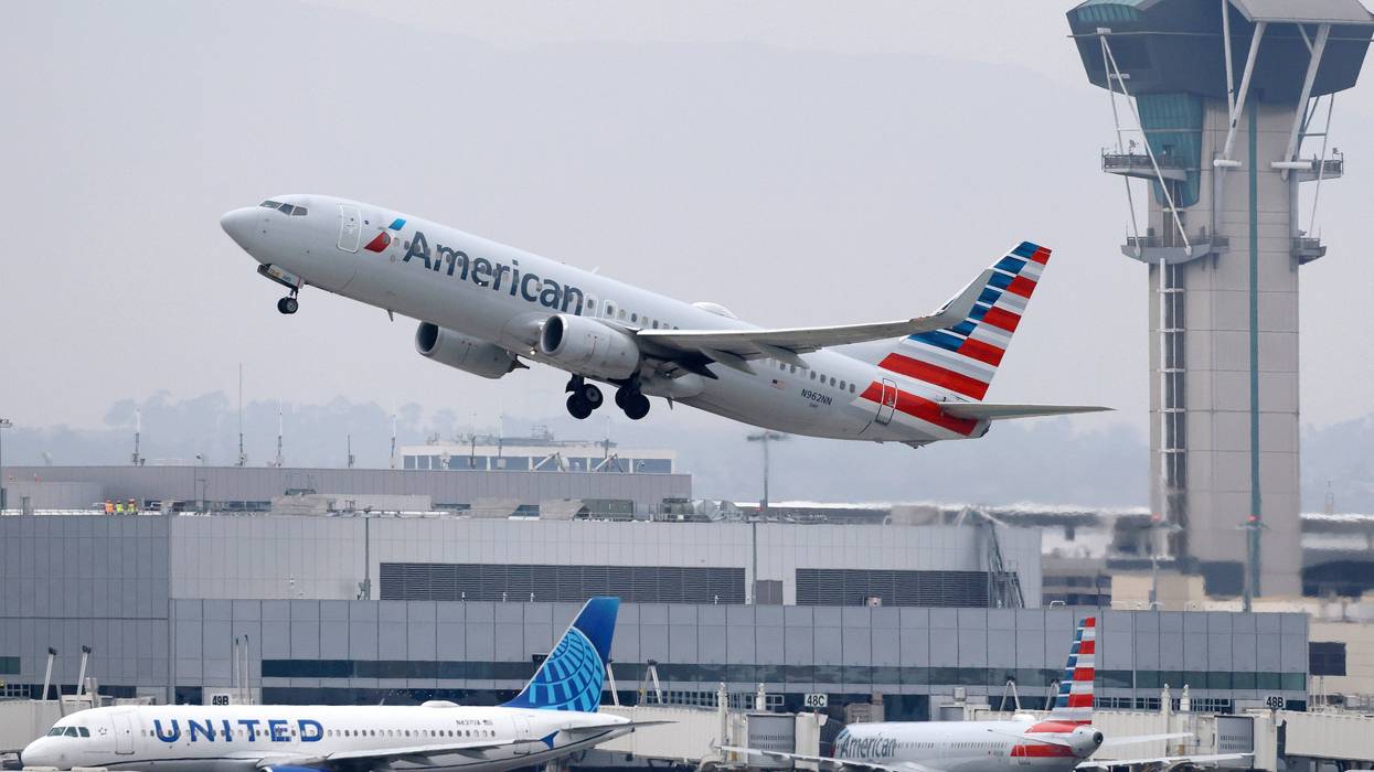 An American Airlines jet takes off with a United aircraft in the background