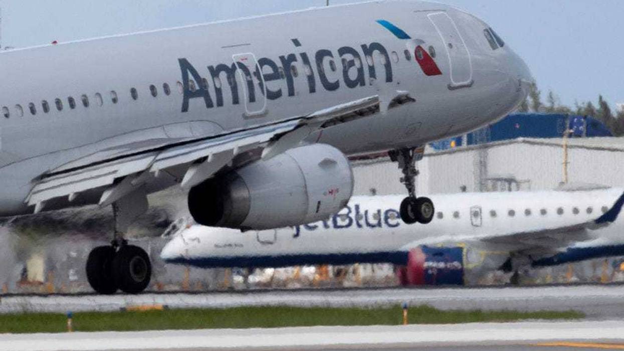 An American Airlines plane lands on a runway near a parked JetBlue plane at the Fort Lauderdale-Hollywood International Airport on July 16, 2020 in Fort Lauderdale, Florida.