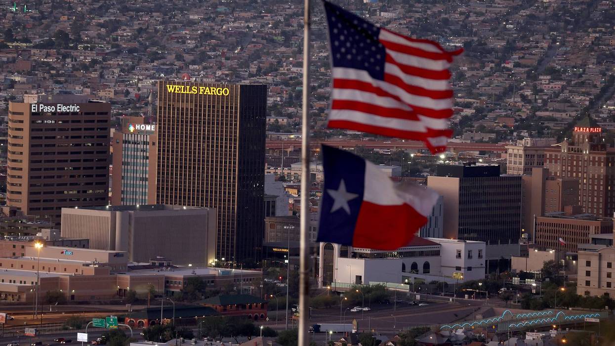 An American and Texas flag are seen flying in front of the skyline of El Paso and Ciudad Juarez on September 23, 2022 in El Paso, Texas