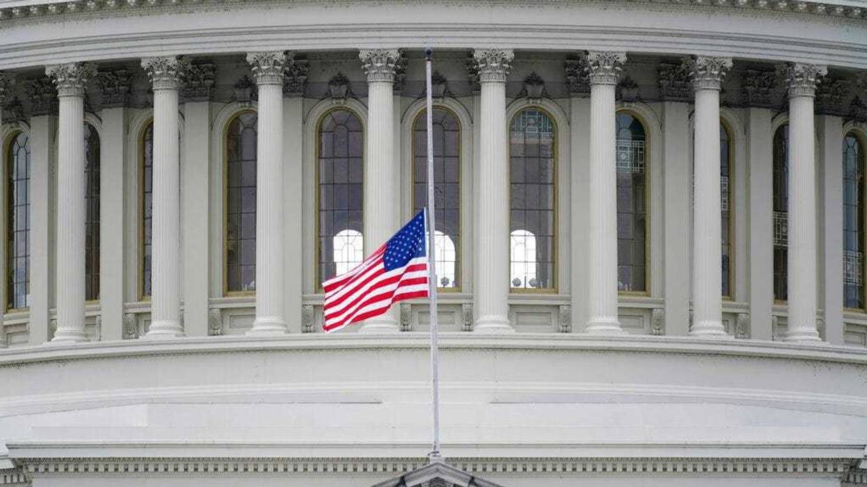 An American flag flies at half-staff in remembrance of U.S. Capitol Police Officer Brian Sicknick above the Capitol Building in Washington, Friday, Jan. 8, 2021.