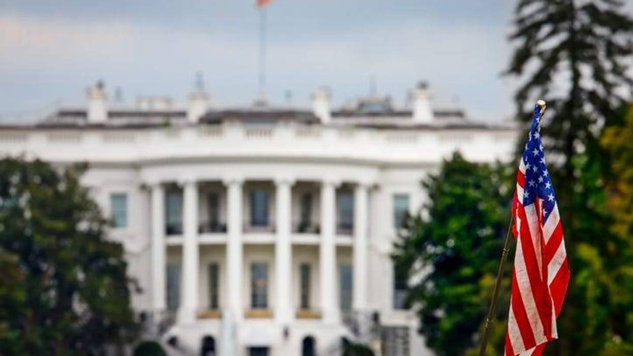An American flag in front of the White House