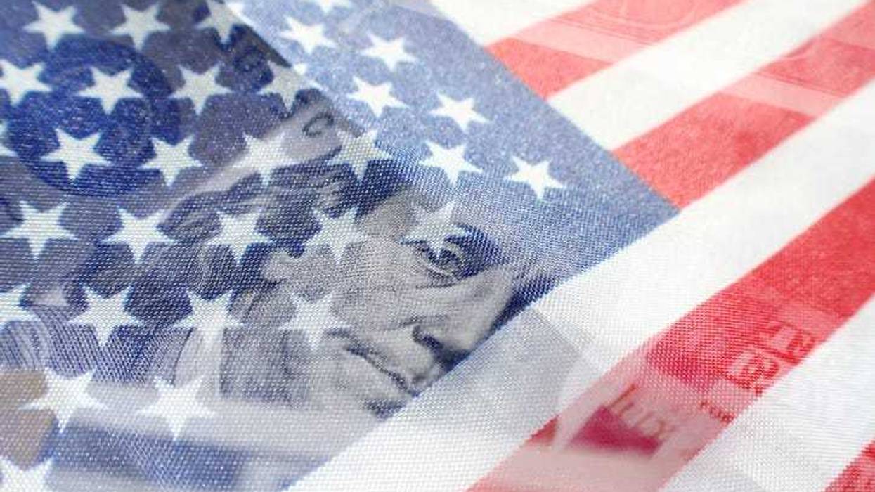 An American flag overlapping a one hundred dollar bill.