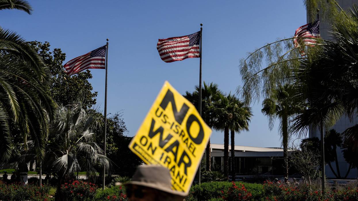 An anti-war demonstrator holds a sign outside the Wilshire Federal Building in Los Angeles Sunday, June 22, 2025, following U.S. airstrikes on Iran's nuclear facilities.