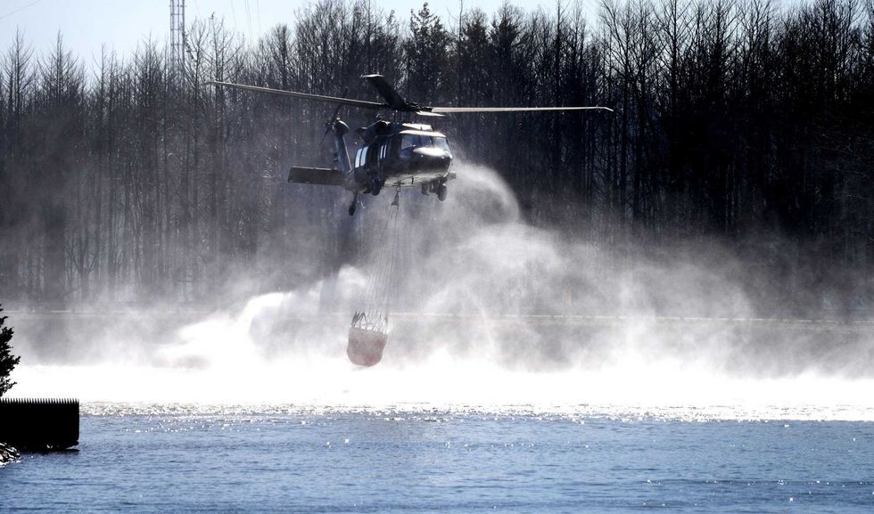 An Army Black Hawk helicopter does water drops around the Oyster Creek Generating Station on April 28, as hot spots from the Jones Road Fire continue to be doused