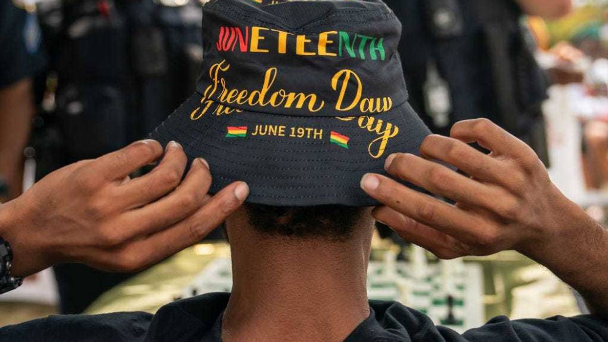 An attendee adjusts his Juneteenth-themed hat during a neighborhood Juneteenth festival on June 17, 2023 in Washington, DC.