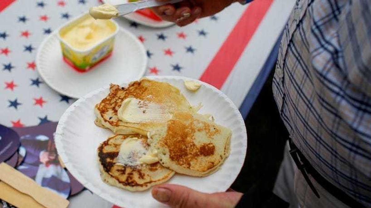 An attendee puts butter on their pancakes during the Democratic Polk County Steak Fry on September 21, 2019 in Des Moines, Iowa.