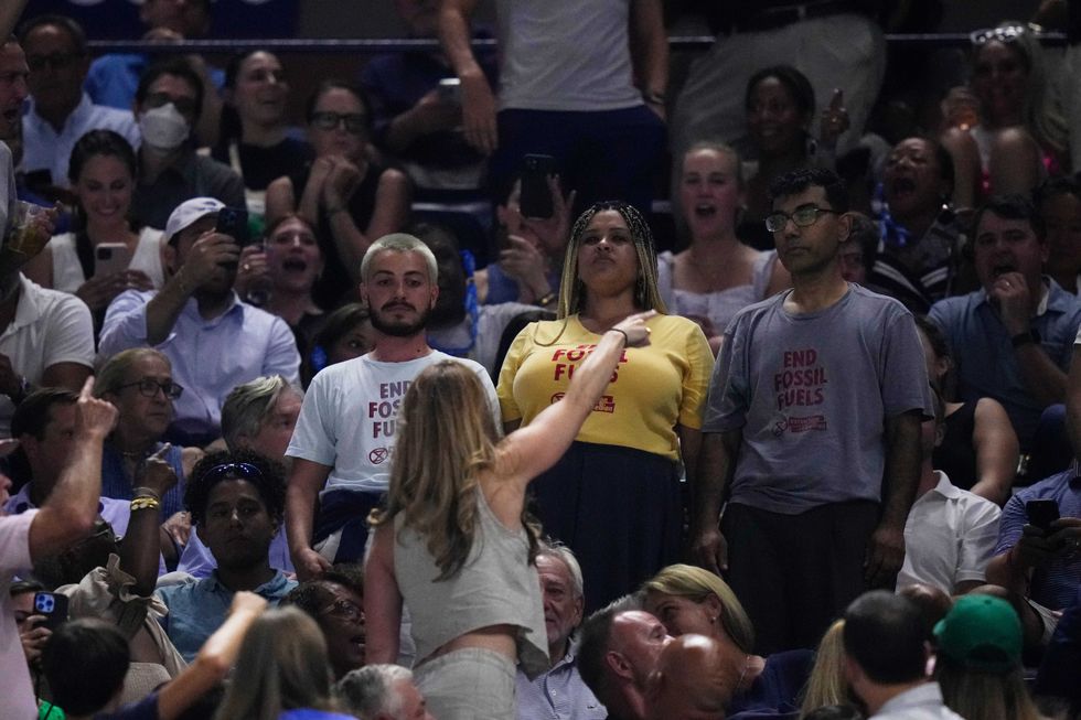 An audience member yells at protesters as they demonstrate at a match between Coco Gauff, of the United States, and Karolina Muchova, of the Czech Republic, during the women