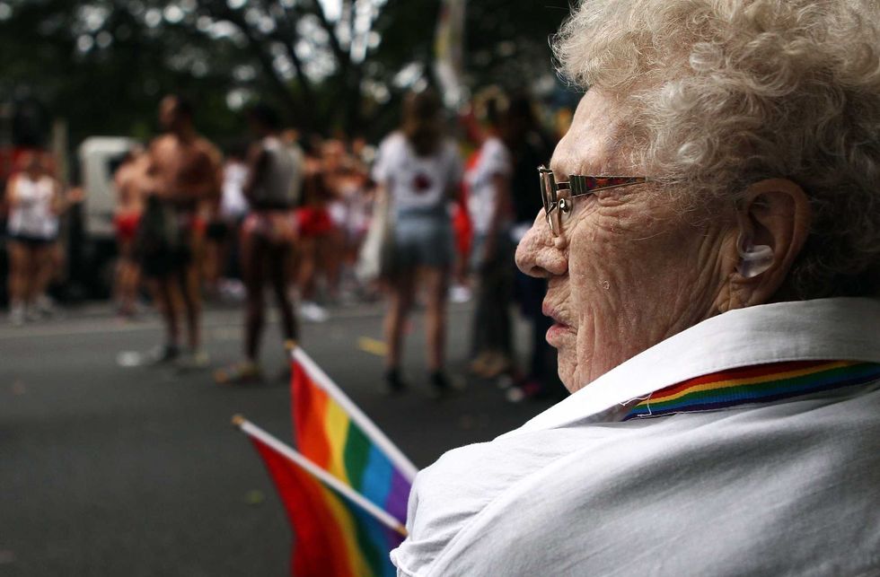An elderly lady watches parade goers prepare prior to the start of the the 2011 Sydney Gay & Lesbian Mardi Gras Parade on March 5, 2011 in Sydney, Australia. (Photo by Mark Metcalfe/Getty Images)