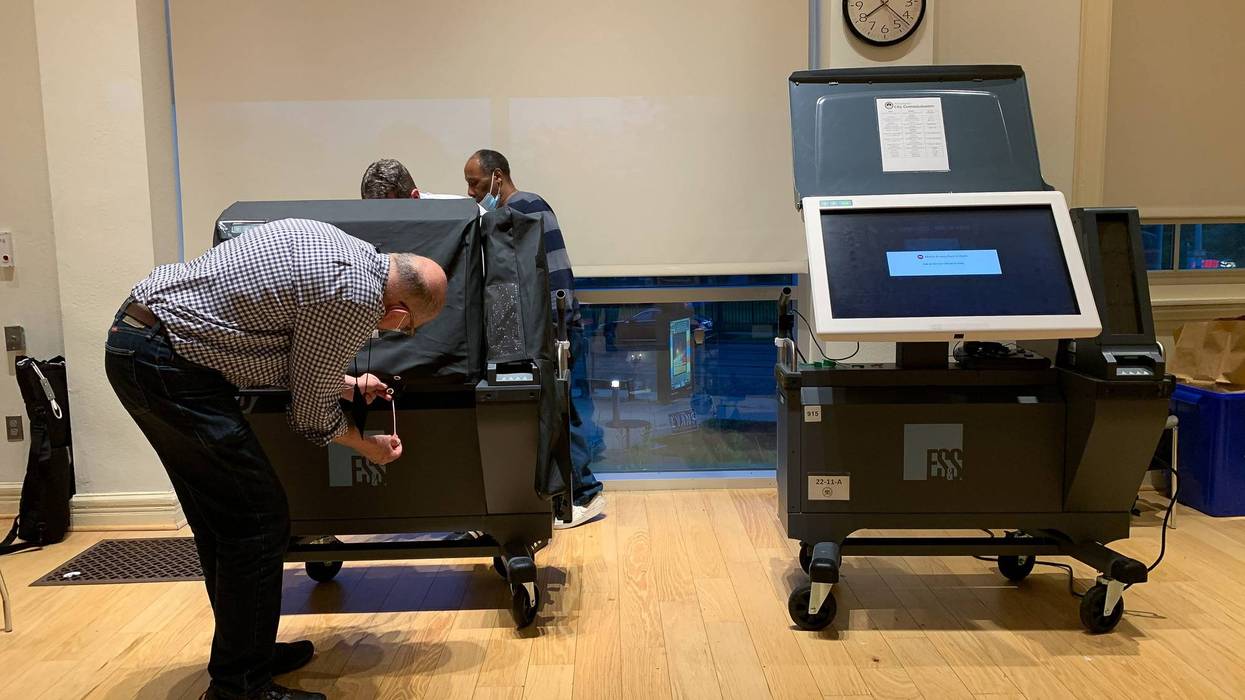 An election worker in Philadelphia, Pennsylvania examines an ExpressVoteXL voting machine during the 2022 primary.