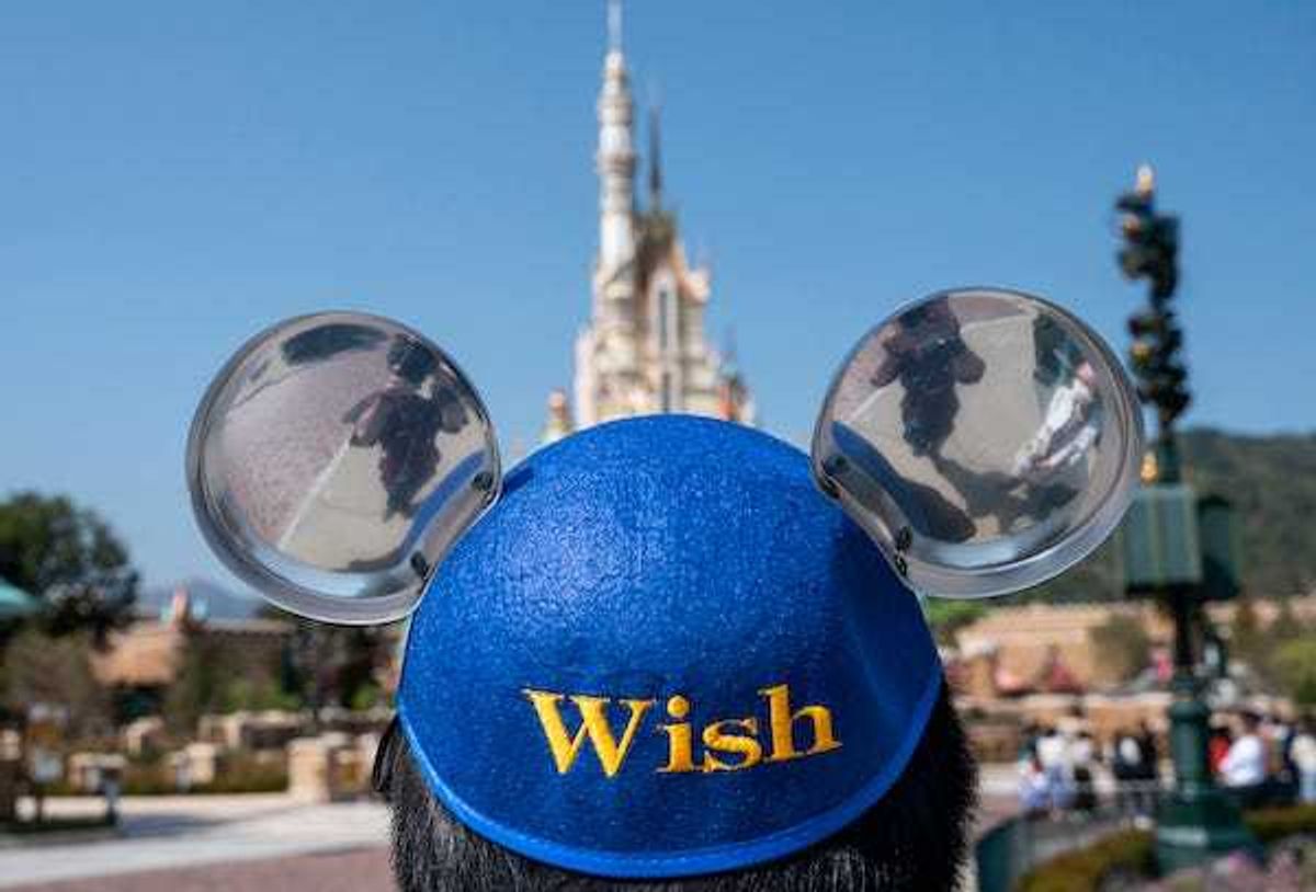 An employee wears a Micky Mouse theme hat at the entrance of the Hong Kong Disneyland Resort