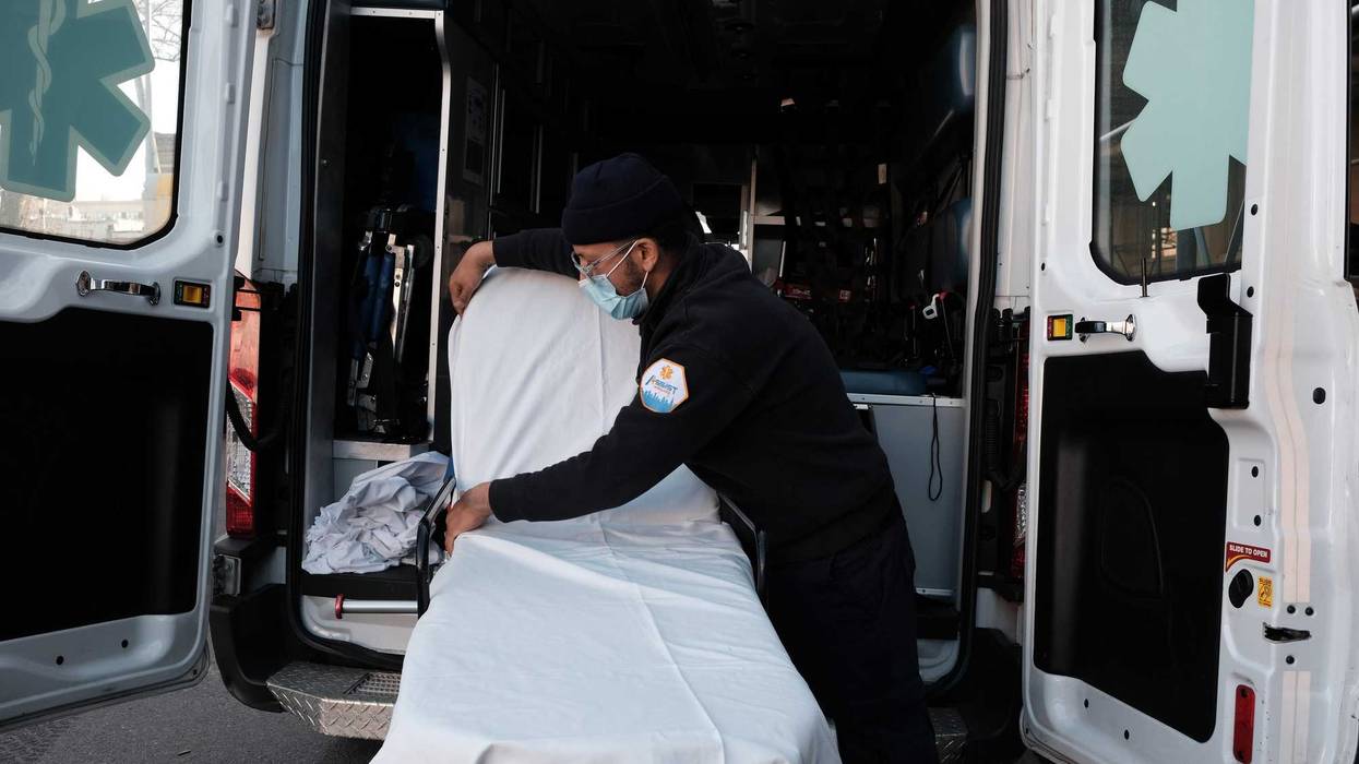 An EMT worker cleans a gurney after transporting a suspected Covid patient outside of a Brooklyn hospital on March, 29 2021 in New York City