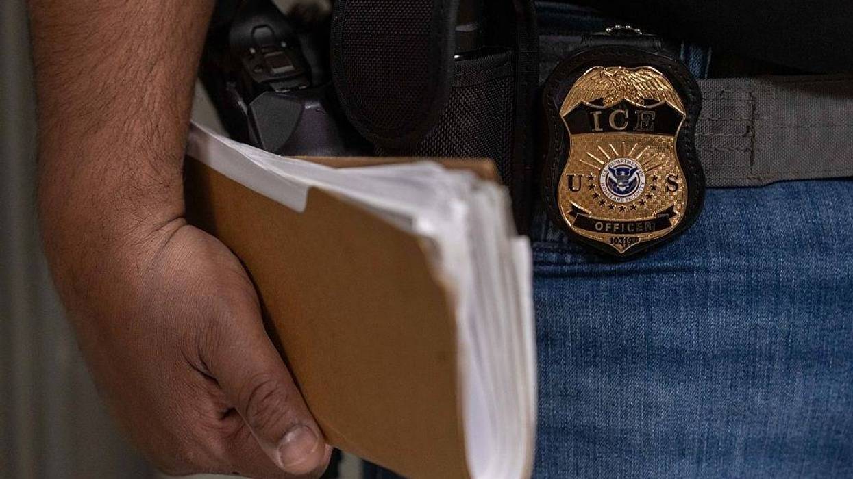 An Immigration and Customs Enforcement (ICE) agent stands outside of immigration court hearings
