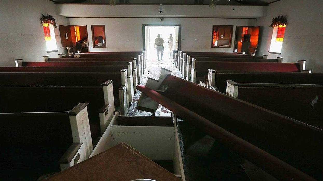 An insurance inspector tours the damaged Bethehem Baptist Church which flooded in Plaquemines Parish on September 5, 2012 in Braithwaite, Louisiana. Louisiana officials estimate that at least 13,000 homes were damaged by Hurricane Isaac. (Photo by Mario Tama/Getty Images)