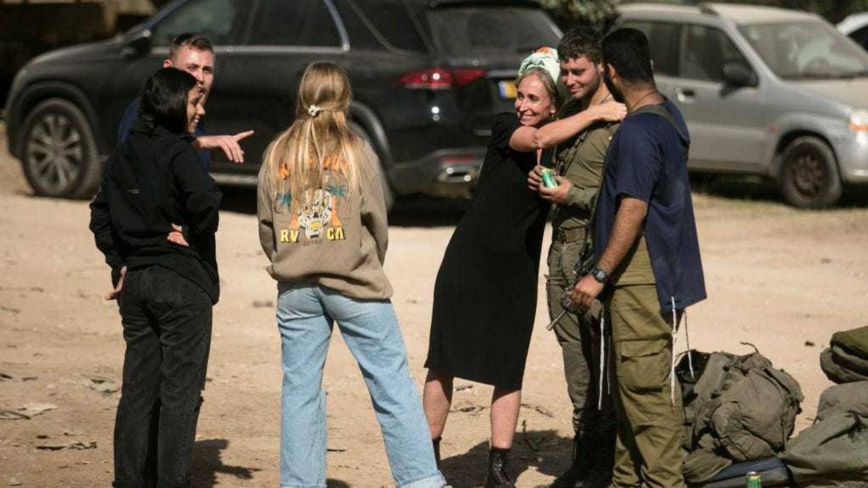 An Israeli soldier who recently exited the Gaza Strip meets his family on November 24, 2023 near the Gaza border in Israel. A total of 50 hostages currently held by Hamas are to be released during a four-day truce with Israel, the first such pause in fighting since Oct. 7, when Hamas launched its surprise attack and Israel responded with a vast military offensive to destroy the militant group that governs Gaza. Under the deal, 150 Palestinian prisoners are also to be released from Israel, and more humanitarian aid will be admitted at the Gaza-Egypt border crossing. (Photo by Amir Levy/Getty Images)