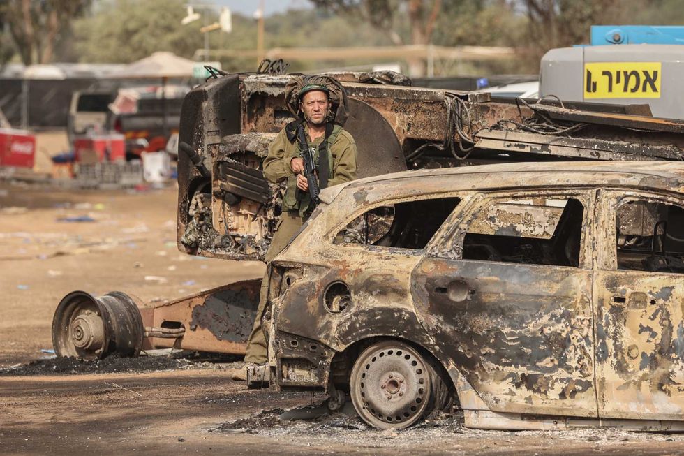 An Israeli solider stands at the grounds of the Supernova electronic music festival after Saturday