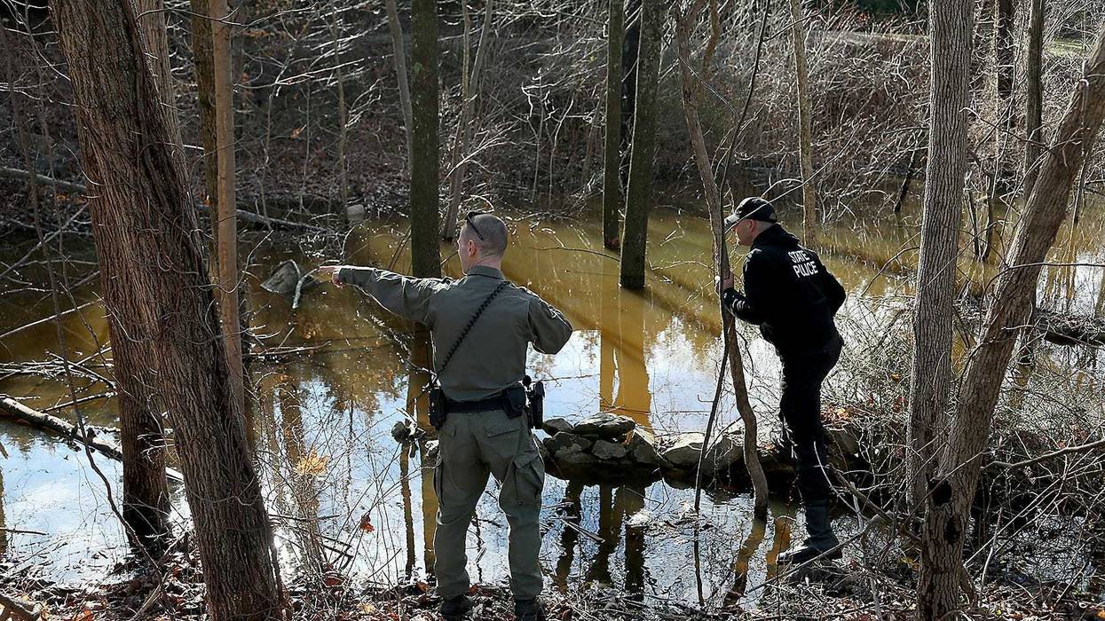 An Massachusetts environmental police officer points out something to a state trooper during their search for Ana Walshe across the street from her home on Rt. 3A in Cohasset on Saturday, Jan. 7, 2023. Cohasset Ana Walshe Missing Person K9 Mass State Police Husband Art Fraud Andy Warhol