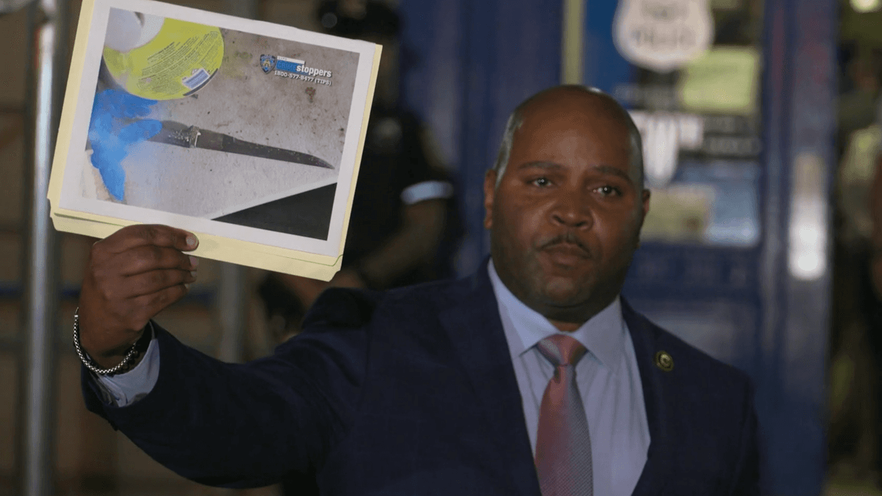 An NYPD official holds a photo of the knife allegedly wielded by the suspect who was fatally shot in a Flatbush apartment on Friday night.