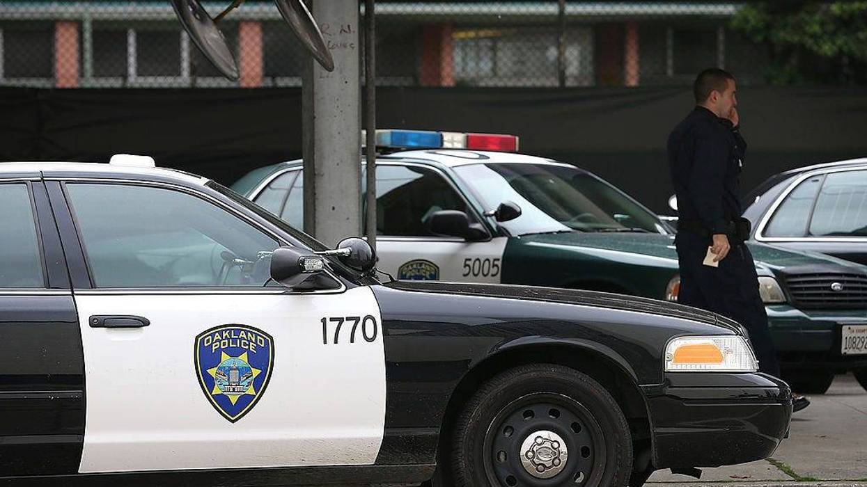 An Oakland Police officer walks by patrol cars at the Oakland Police headquarters on December 6, 2012 in Oakland, California.