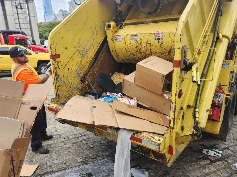 An office chair from the encampment sits alongside cardboard in a Department of Transportation garbage truck.