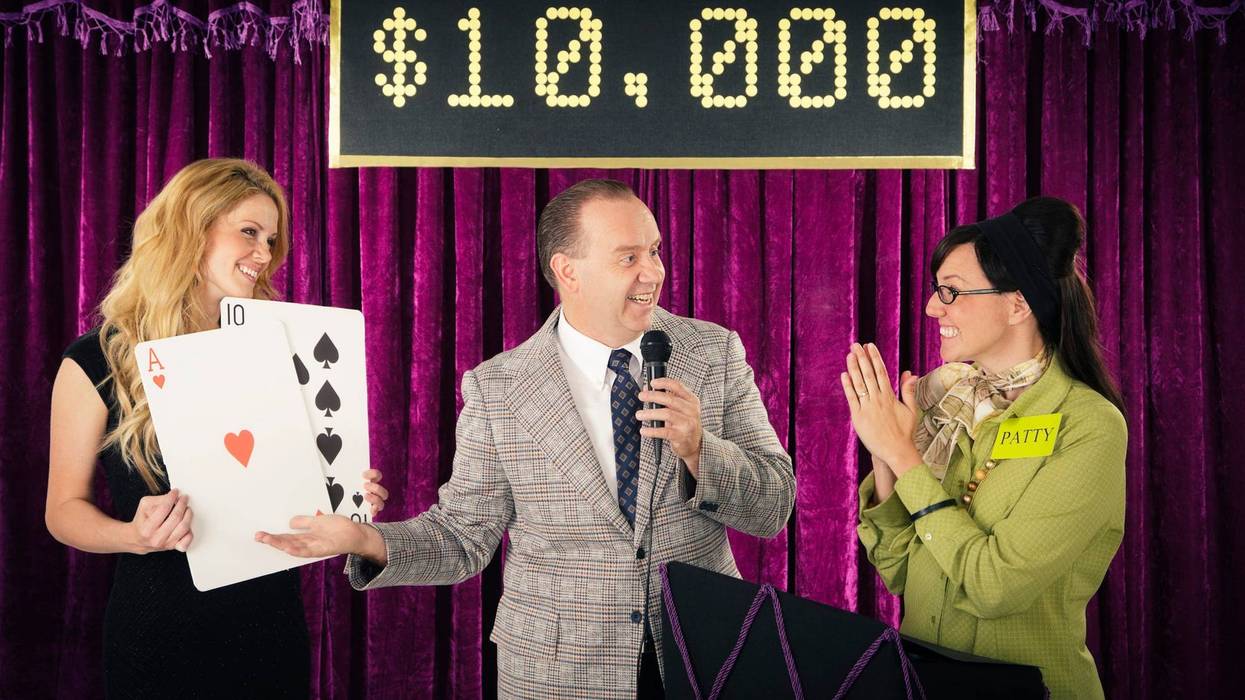 An old fashioned game show host holding a microphone standing with the contestant and assistant.