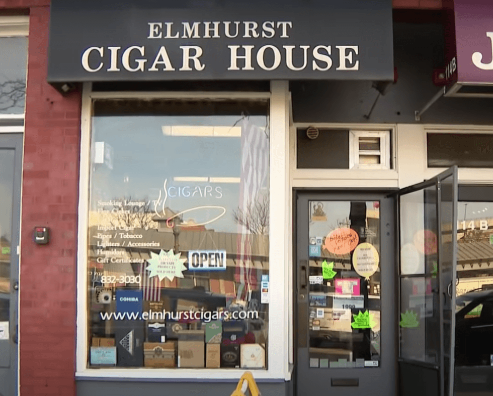 An orange sign on the door of the Elmhurst Cigar House reads “Biden voters keep out!”