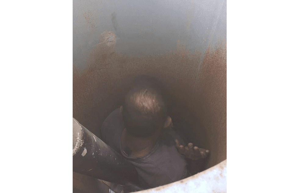 An overhead shot of the man trapped inside the shaft of a vineyard fan.