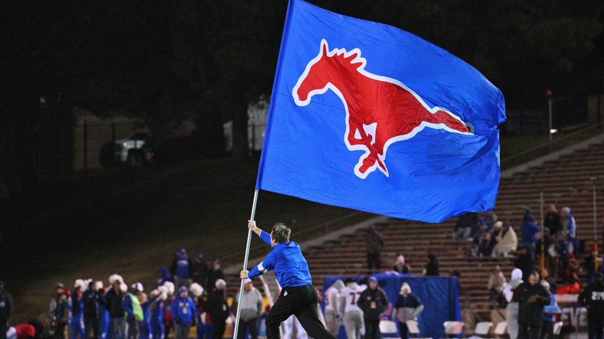 An SMU Mustangs cheerleader carries a flag on the field after the Mustangs scored a touchdown during the second half of the New Mexico Bowl game between the Mustangs and the Brigham Young Cougars at University Stadium on December 17, 2022 in Albuquerque, New Mexico.