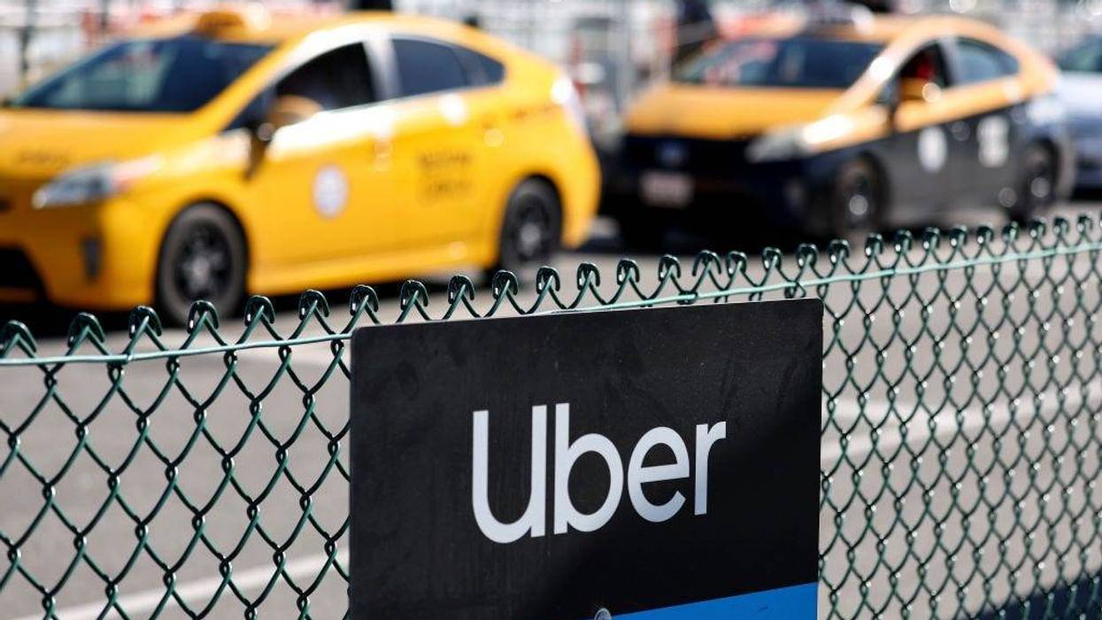 An Uber rideshare sign is posted nearby as taxis wait to pick up passengers at Los Angeles International Airport (LAX) on February 8, 2023 in Los Angeles, California.
