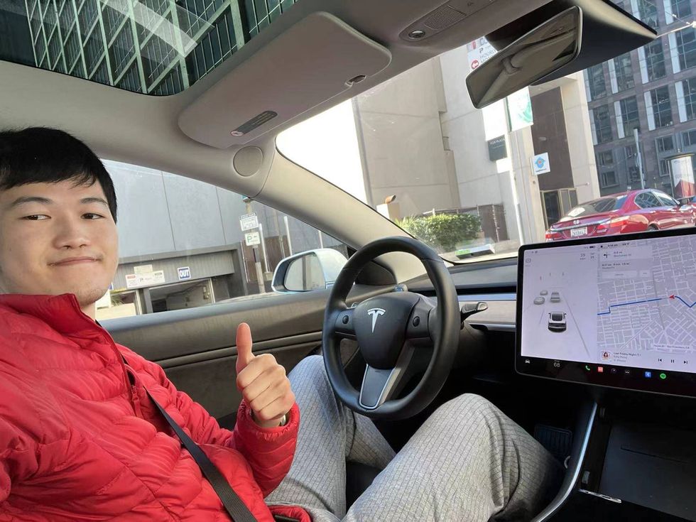 An undated photo of Christopher Liang in a Tesla.