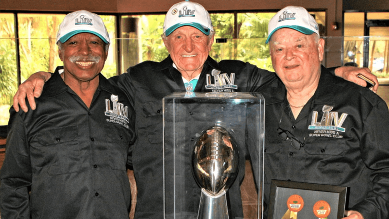 An undated photo of friends Gregory Eaton (L), Tom Henschel (C) and Don Crisman (R) posing with a replica of the Vince Lombardi Trophy before Super Bowl LIV in 2020. The trio has attended all 55 Super Bowls and the Feb. 13, 2022 game at SoFi Stadium will be their 56th.