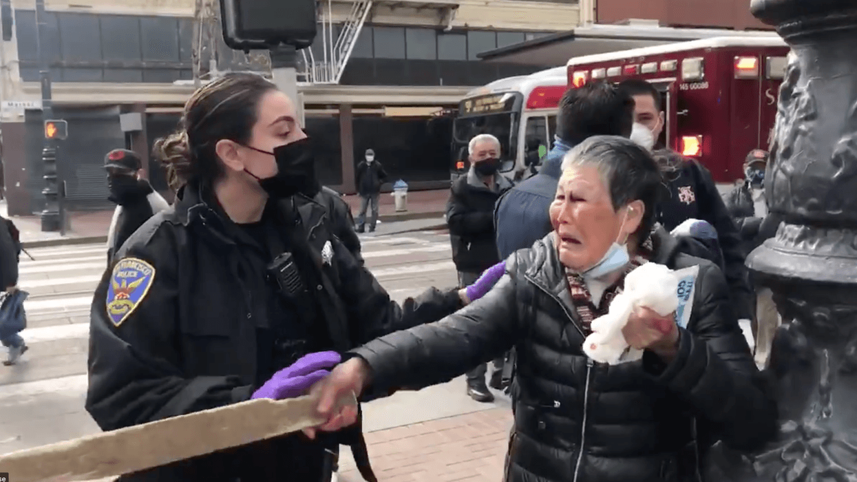 An unidentified Asian woman, the victim of an allegedly unprovoked daytime attack, seen in a video taken Wednesday along Market St. in San Francisco.