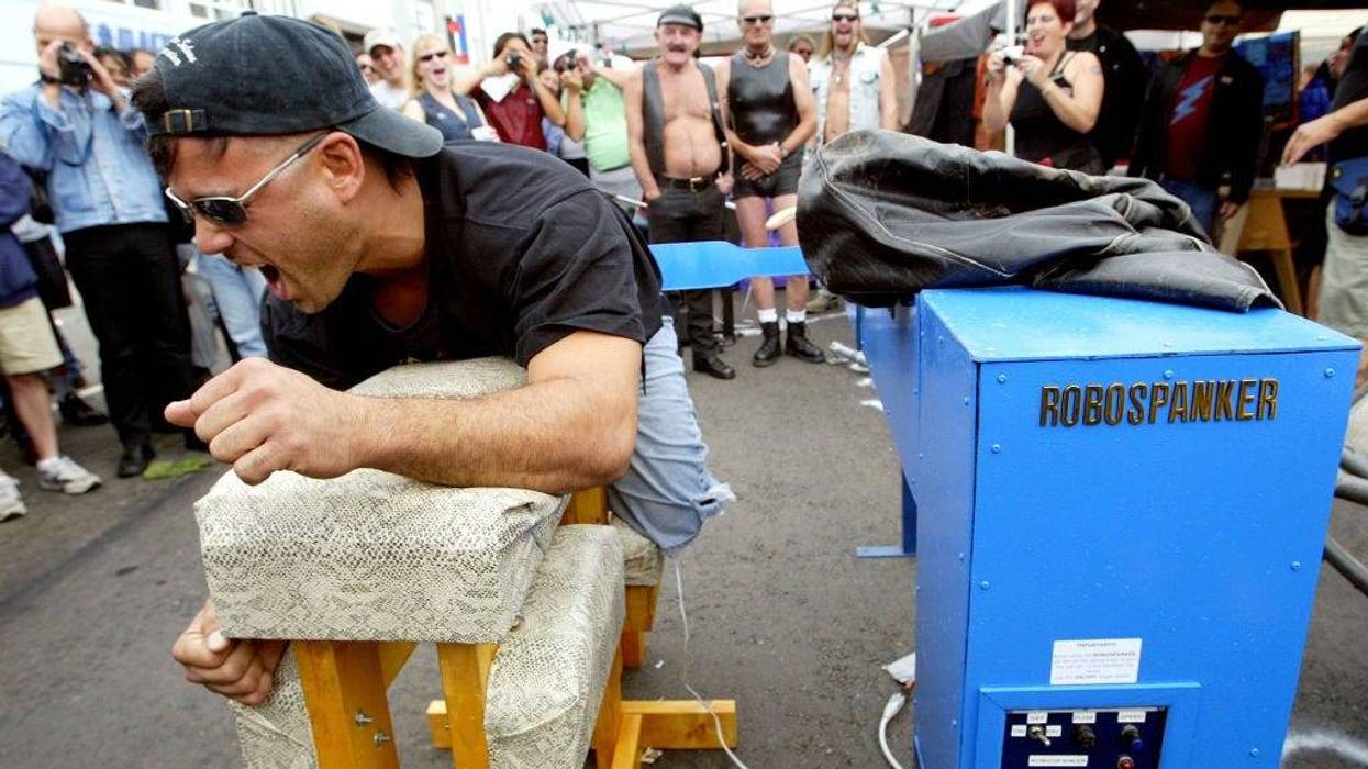 An unidentified man reacts after being spanked by the "Robospanker" spanking machine at the 20th Annual Folsom Street Fair September 28, 2003 in San Francisco, California.