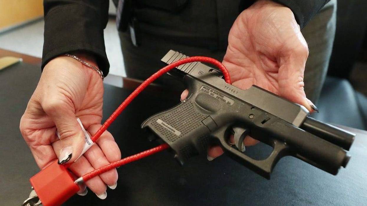 An unloaded handgun with a cable lock